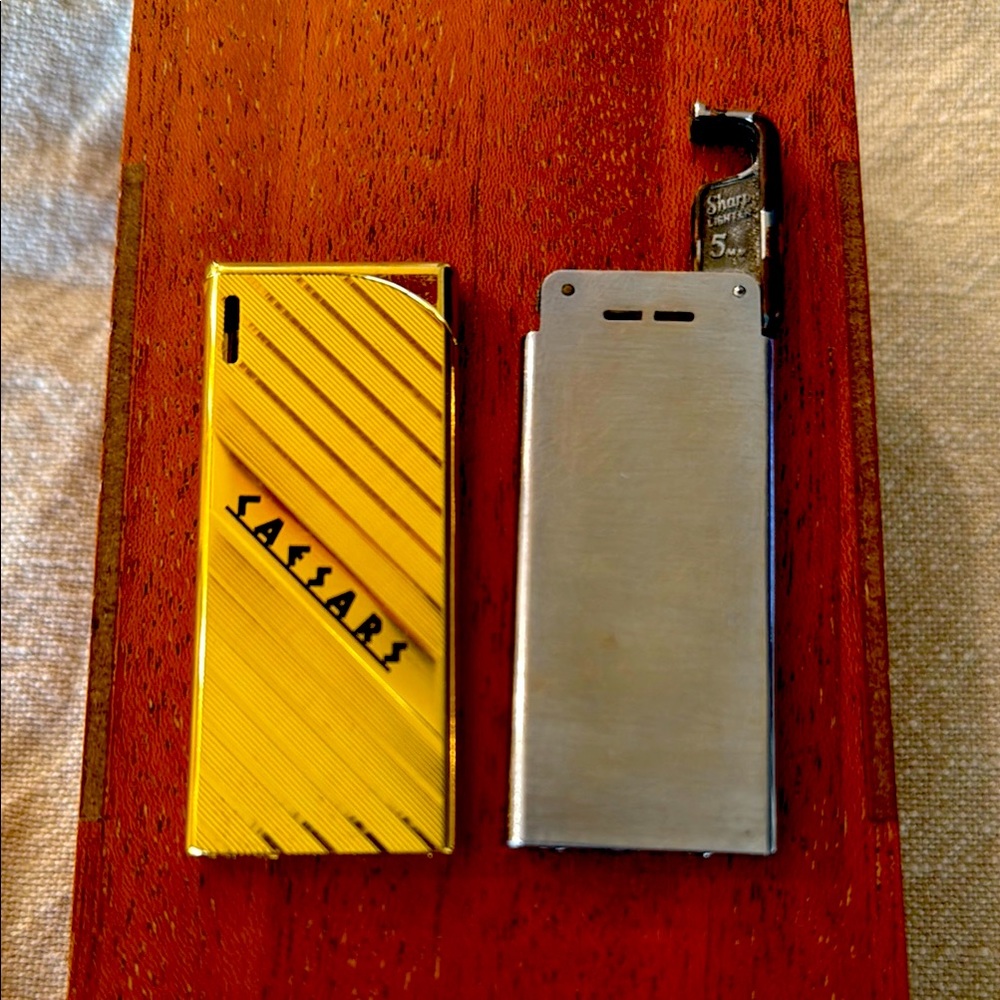 Vintage collectible 5mm lighters - empty 
Gold Caesars Palace and Sharp lighter.
